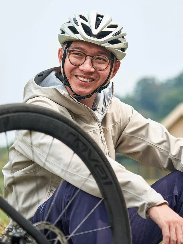 自転車ヘルメットをかぶった男性が笑顔でポーズ、アウトドアサイクリングスタイル